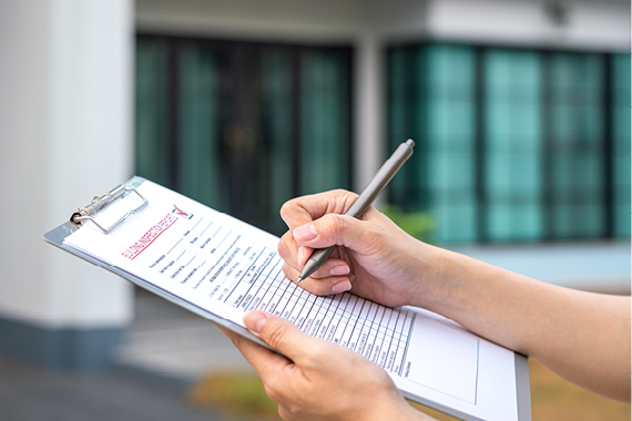 Hands holding a grey clipboard.