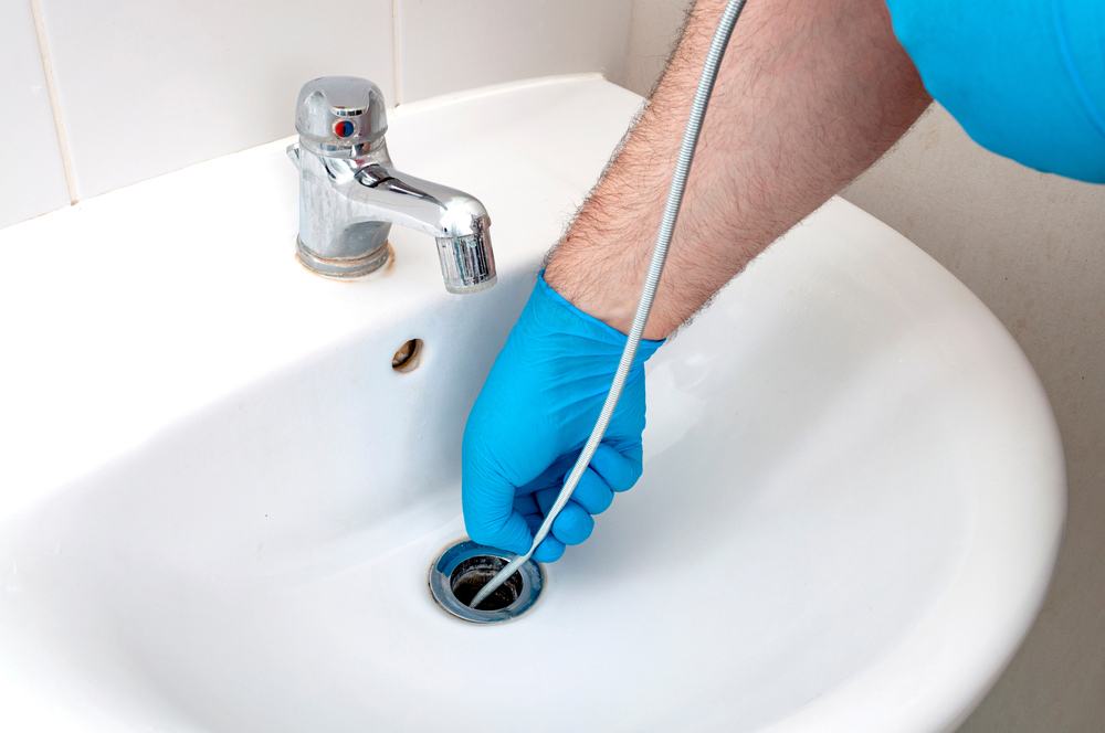 Plumber Fixing Blocked Drain